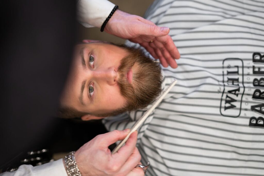 pexels-photo-3998424 A bearded man receives grooming care at a professional barber shop.